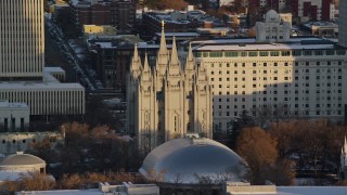 AX127_115E - 5.5K aerial stock footage orbit Salt Lake Temple in downtown at sunset in wintertime, Salt Lake City, Utah