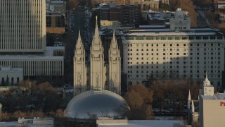 AX127_116 - 5.5K stock footage aerial video orbit of Salt Lake Temple at sunset with wintertime snow, Salt Lake City, Utah