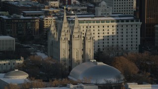 AX127_117 - 5.5K stock footage aerial video of orbiting Salt Lake Temple at sunset with winter snow, Salt Lake City, Utah
