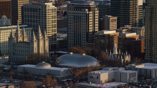 AX127_118E - 5.5K aerial stock footage orbit Salt Lake Temple and Tabernacle at sunset with winter snow, Salt Lake City, Utah