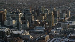 AX127_121 - 5.5K stock footage aerial video of circling Salt Lake Temple, Tabernacle and Assembly Hall in downtown with winter snow at sunset, Utah