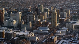AX127_121E - 5.5K aerial stock footage of Salt Lake Temple, Tabernacle and Assembly Hall in downtown with winter snow at sunset, Utah