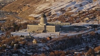 AX127_126E - 5.5K aerial stock footage fly away from the Utah State Capitol with winter snow at sunset in Salt Lake City