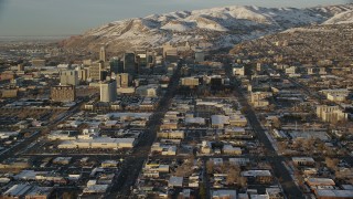 AX127_131 - 5.5K stock footage video of reverse view of wide streets through Downtown Salt Lake City at sunset in winter, Utah