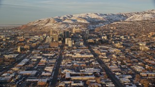 AX127_132 - 5.5K stock footage aerial video of wide city streets through Downtown Salt Lake City at sunset with winter snow, Utah