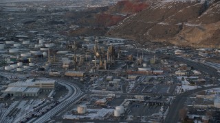 AX127_167 - 5.5K stock footage aerial video orbit Tesoro Refinery in Salt Lake City at sunset with winter snow, Utah