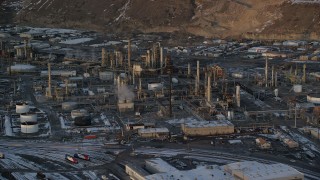 AX127_168 - 5.5K stock footage aerial video orbit of the Tesoro Refinery with winter snow at sunset, Salt Lake City, Utah