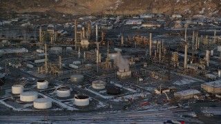AX127_169 - 5.5K stock footage aerial video of circling the Tesoro Refinery in Salt Lake City with winter snow at sunset, Utah