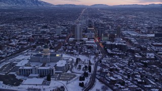 AX128_005E - 5.5K aerial stock footage orbit Downtown Salt Lake City and reveal the state capitol with winter snow at twilight, Utah