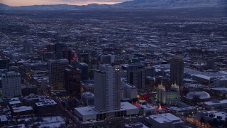 AX128_019 - 5.5K aerial stock footage orbit Church Office Building and temple in Downtown Salt Lake City with winter snow at twilight, Utah