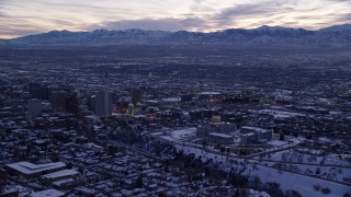 AX128_020E - 5.5K aerial stock footage of a wide orbit of state capitol and Downtown Salt Lake City with winter snow at twilight, Utah