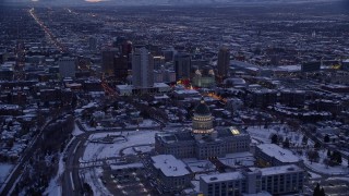 AX128_022E - 5.5K aerial stock footage fly over Utah State Capitol toward church buildings and temple with snow at twilight, Downtown Salt Lake City