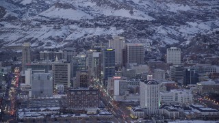 AX128_033 - 5.5K stock footage aerial video of Main Street and Downtown Salt Lake City, Utah buildings with winter snow at twilight