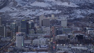 AX128_034 - 5.5K stock footage aerial video of passing State Street through Downtown Salt Lake City to capitol building with winter snow at twilight, Utah