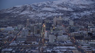 AX128_038 - 5.5K aerial stock footage orbit State, Main and West Temple Streets through Downtown Salt Lake City, to Utah capitol with snow at twilight