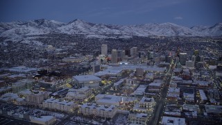 AX128_045 - 5.5K aerial stock footage of the Gateway, arena, convention center and Downtown Salt Lake City with winter snow at twilight, Utah