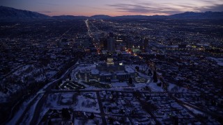 AX128_050E - 5.5K aerial stock footage of circling north of the Utah State Capitol building and Downtown Salt Lake City with winter snow at twilight