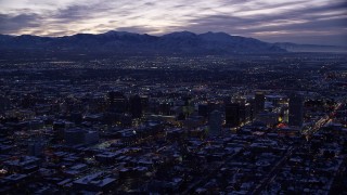 AX128_055E - 5.5K aerial stock footage of a wide view of Downtown Salt Lake City, Utah with winter snow at twilight