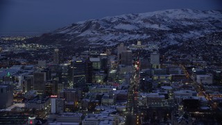 AX128_062 - 5.5K stock footage aerial video orbit Downtown Salt Lake City and State Street to the capitol with winter snow at Night, Utah