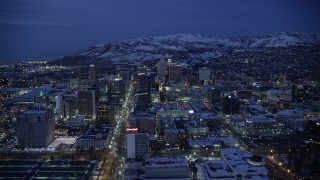 AX128_072 - 5.5K stock footage aerial video fly over Main Street toward State Street in Downtown SLC with winter snow at night, Utah