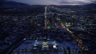 AX128_079 - 5.5K stock footage aerial video fly over Utah State Capitol and approach State Street through Downtown SLC in winter twilight
