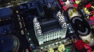 AX128_082 - 5.5K stock footage aerial video bird's eye orbit of Salt Lake Temple with Christmas lights and snow at night, Downtown Salt Lake City, Utah