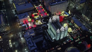 AX128_083 - 5.5K stock footage aerial video orbit Salt Lake Temple with snow and Christmas lights at night, Downtown Salt Lake City, Utah