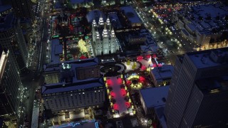AX128_086 - 5.5K stock footage aerial video orbit fountains and Christmas lights at Salt Lake Temple with winter snow at night, Downtown Salt Lake City, Utah