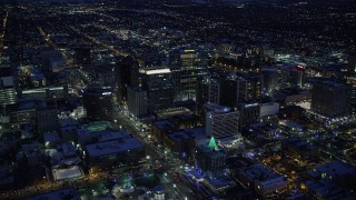 AX128_089 - 5.5K stock footage aerial video of Downtown Salt Lake City office buildings and city streets in winter at night, Utah