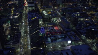 AX128_091 - 5.5K stock footage aerial video orbit Wells Fargo Building to reveal Gallivan Center with winter snow at night, Downtown Salt Lake City, Utah