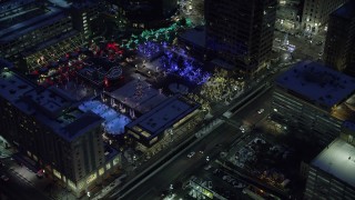 AX128_093 - 5.5K stock footage aerial video orbit Christmas tree at Gallivan Center and reveal ice skating rink in winter at night, Downtown Salt Lake City, Utah