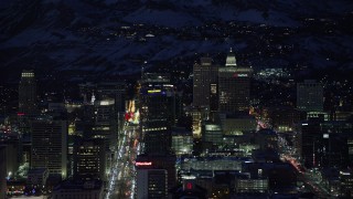 AX128_100 - 5.5K stock footage aerial video of tall office buildings around Main Street in Downtown Salt Lake City, Utah in winter at night