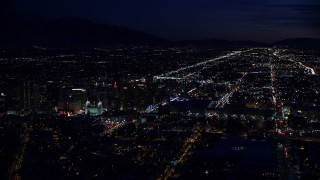 AX128_110 - 5.5K aerial stock footage wide orbit of Salt Lake Temple and Downtown Salt Lake City, Utah at night in winter