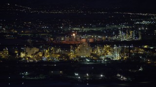 AX128_112 - 5.5K stock footage aerial video orbiting a large Salt Lake City refinery at night in winter, Utah