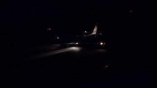 AX128_114E - 5.5K aerial stock footage track private jet touching down at SLC Airport at night in winter, Utah