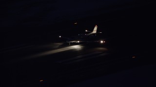AX128_116 - 5.5K aerial stock footage track private jet touching down at SLC Airport at night in winter, Utah