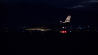 AX128_121E - 5.5K aerial stock footage track private jet taxiing off SLC Airport runway at night in wintertime, Utah