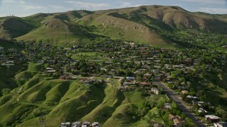 AX129_058 - 5.5K aerial stock footage of flying by suburban neighborhood, Wasatch Range foothills, Salt Lake City, Utah