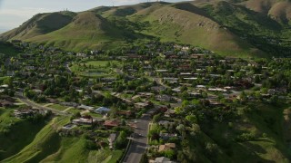 AX129_059 - 5.5K aerial stock footage of flying by hilltop suburban neighborhood, Wasatch Range, Salt Lake City, Utah