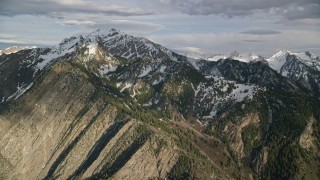 AX129_103E - 5.5K aerial stock footage of passing by snow-capped peaks of Wasatch Range, Utah