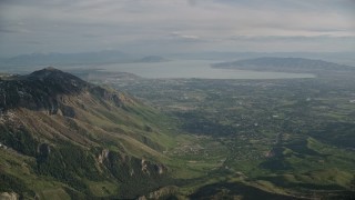 AX129_119 - 5.5K aerial stock footage of flying by American Fork, Utah Lake, seen from Wasatch Range, Utah