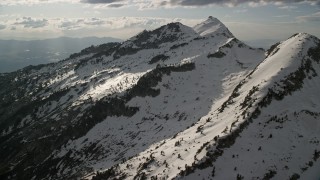 AX129_120E - 5.5K aerial stock footage of passing by Lone Peak in snowy Wasatch Range, Utah