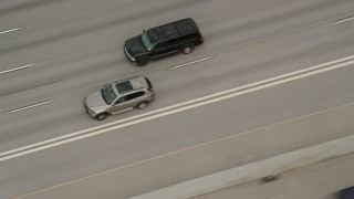 AX130_015E - 5.5K aerial stock footage video of tracking a black SUV passing light traffic on I-15, Salt Lake City, Utah