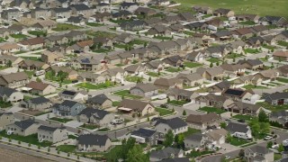 AX130_028 - 5.5K aerial stock footage of flying by suburban tract homes, West Jordan, Utah