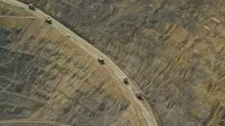 AX130_043 - 5.5K aerial stock footage of flying by gravel haulers, Kennecott Copper Mine, Bingham Canyon Mine, Utah