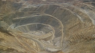 AX130_044E - 5.5K aerial stock footage orbit of gravel haulers, Kennecott Copper Mine aka Bingham Canyon Mine, Utah