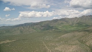 AX130_075 - 5.5K aerial stock footage of flying by green ridges of the Oquirrh Mountains, Utah