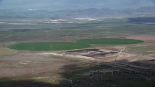 AX130_088 - 5.5K aerial stock footage of passing by two green circular crop fields, Elberta, Utah