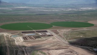 AX130_090 - 5.5K aerial stock footage flyby two green circular crop fields, Elberta, Utah