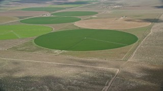 AX130_091E - 5.5K aerial stock footage of approaching circular crop field, tilt to irrigation system, Elberta, Utah